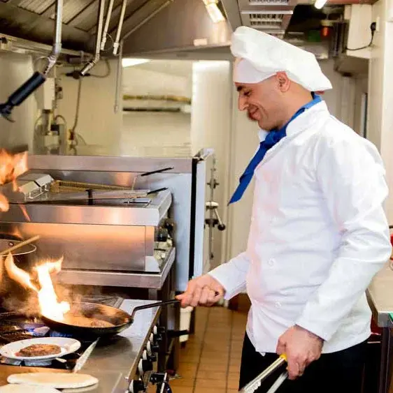 Riverwalk Estates Chef Created Meals, chef frying a dish.