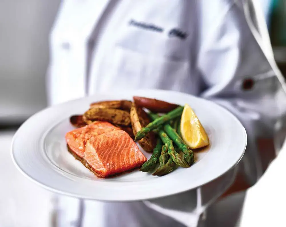Riverwalk Estates Chef Created Meals, chef delivering a finished dish.